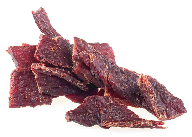Portion of delicious beef jerky isolated on a white background. Pile of dried spiced meat.